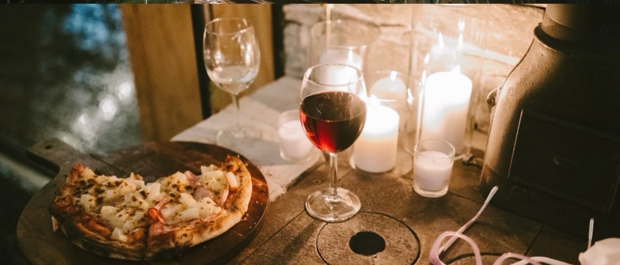Candlelit dinner table with wine goblets and floral centerpiece